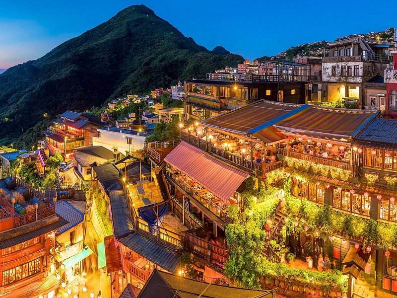Red lanterns lighting the stacked teahouses of Jiufen Old Street at dusk