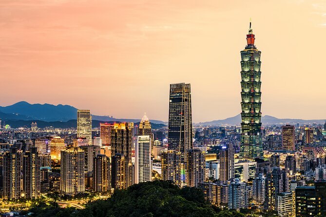 The Taipei skyline at sunset with Taipei 101 and the mountains behind it