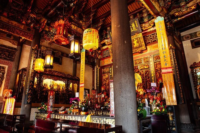 Hanging lanterns and gilded panels above the altar inside a Taipei temple